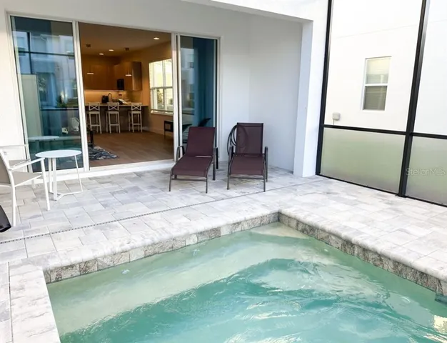 a kitchen with granite countertop a table chairs microwave and refrigerator