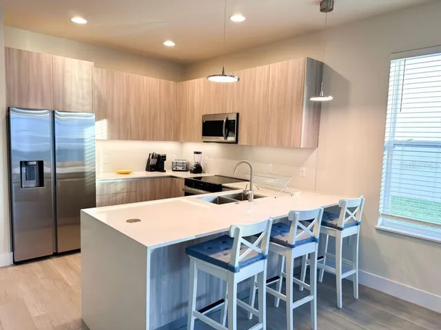 a kitchen with stainless steel appliances wooden cabinets a sink and a refrigerator