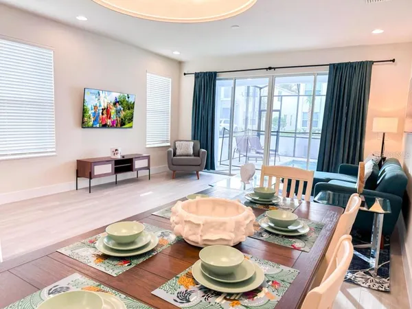 a living room with furniture a wooden floor and a dining table