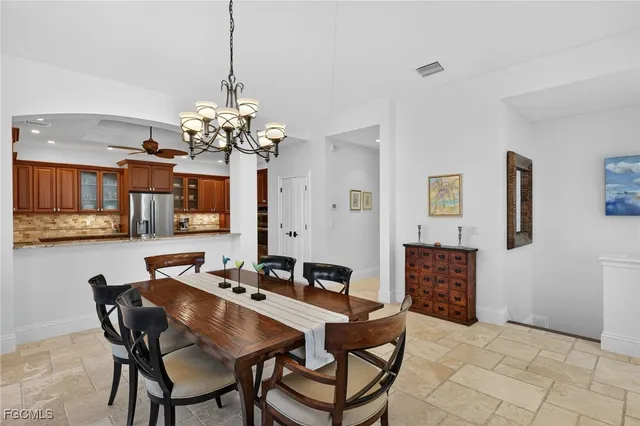 a dining room with wooden floor a chandelier a wooden table and chairs