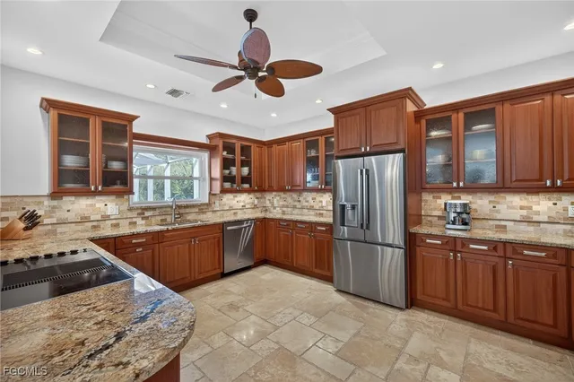 a kitchen with stainless steel appliances granite countertop a stove refrigerator sink and microwave