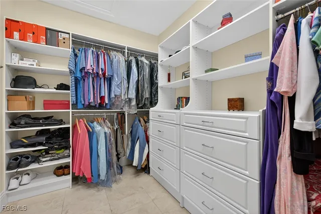 a view of walk in closet with clothes and shoes