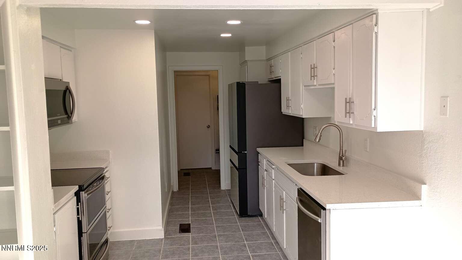 68 Condor Circle Carson City, NV 89701 - Photo 11 of 23 a kitchen that has a sink a refrigerator and a stove