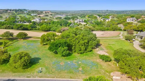 a view of a big yard with plants and large trees