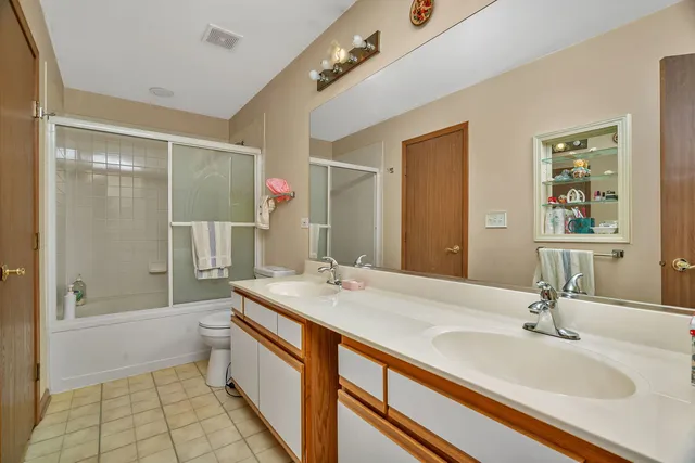 a bathroom with a sink a toilet a mirror and shower