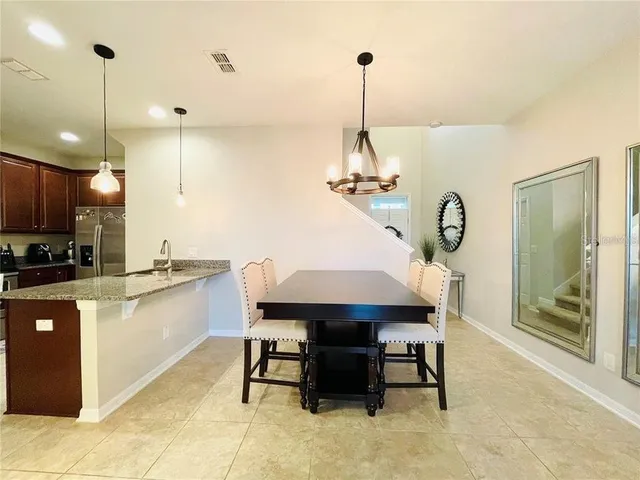 a kitchen with kitchen island granite countertop a table and chairs in it