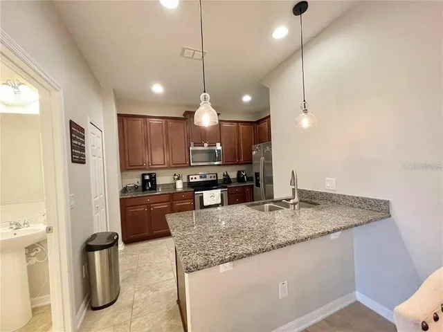 a kitchen with stainless steel appliances granite countertop a sink stove and refrigerator