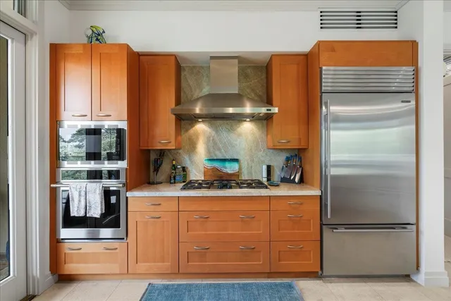a kitchen with kitchen island granite countertop a refrigerator and a stove
