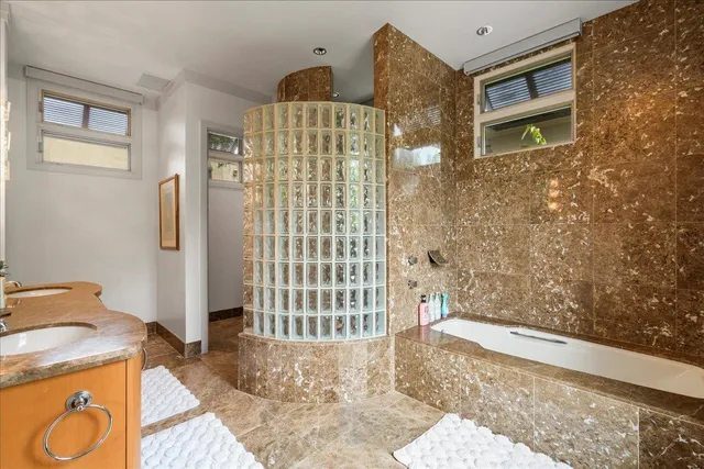 a bathroom with a granite countertop sink a mirror and shower