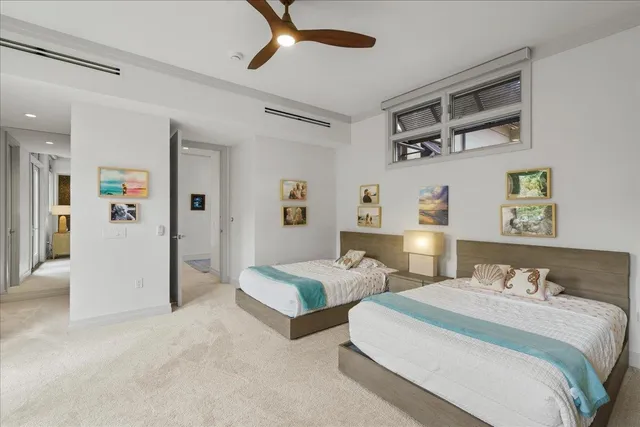 a bedroom with two beds and painting on the wall