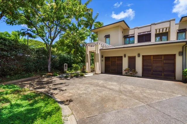 a front view of a house with a yard and a garage