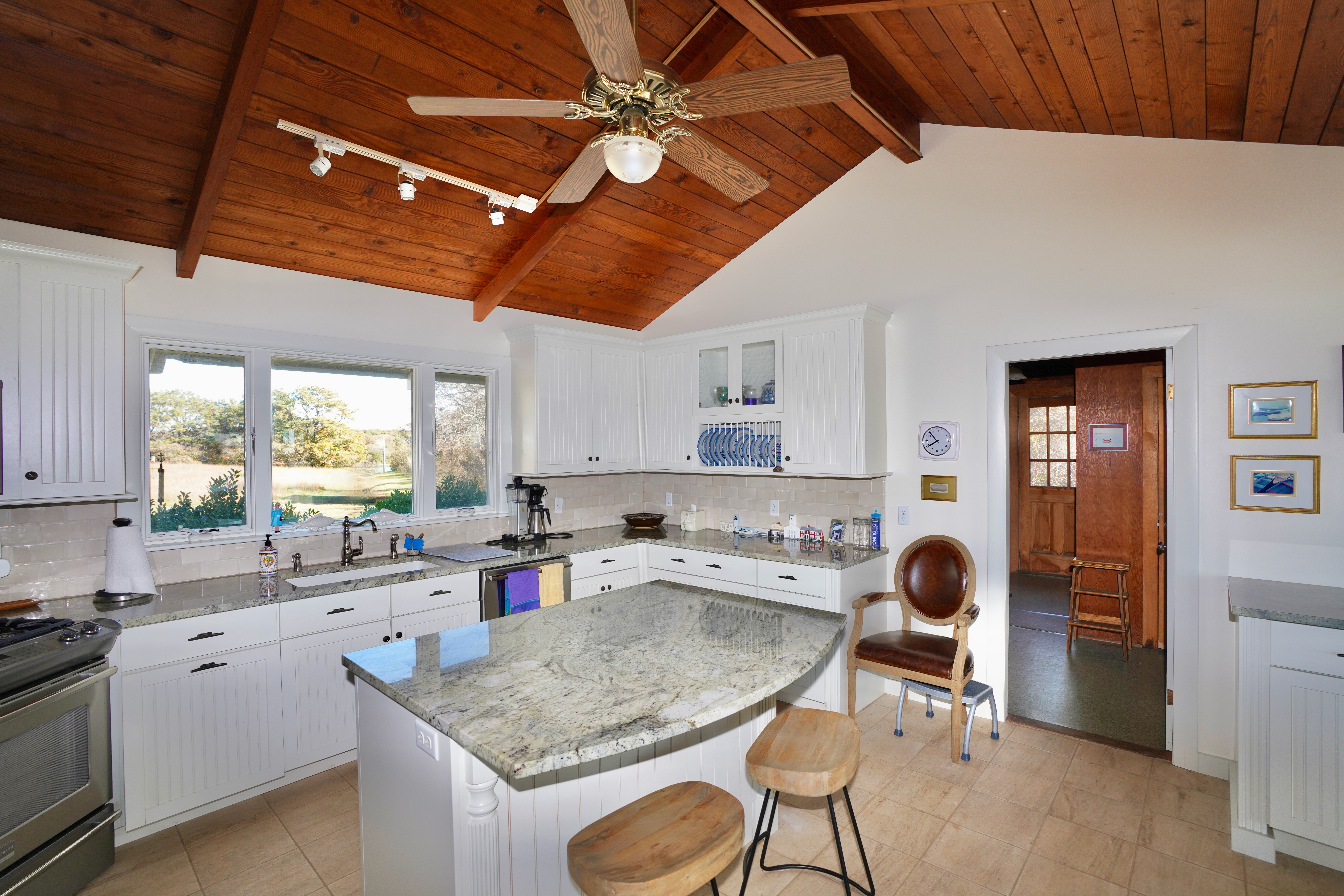 30 Calebs Pond Road Edgartown, MA 02539 - Photo 15 of 35 a kitchen with a stove a sink a dining table and chairs