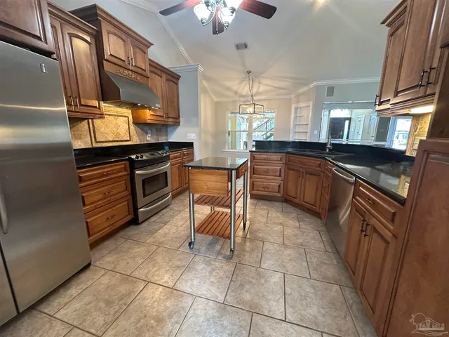 a kitchen with granite countertop a refrigerator stove and sink