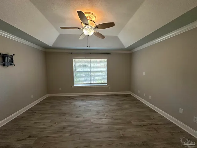 an empty room with windows and fan