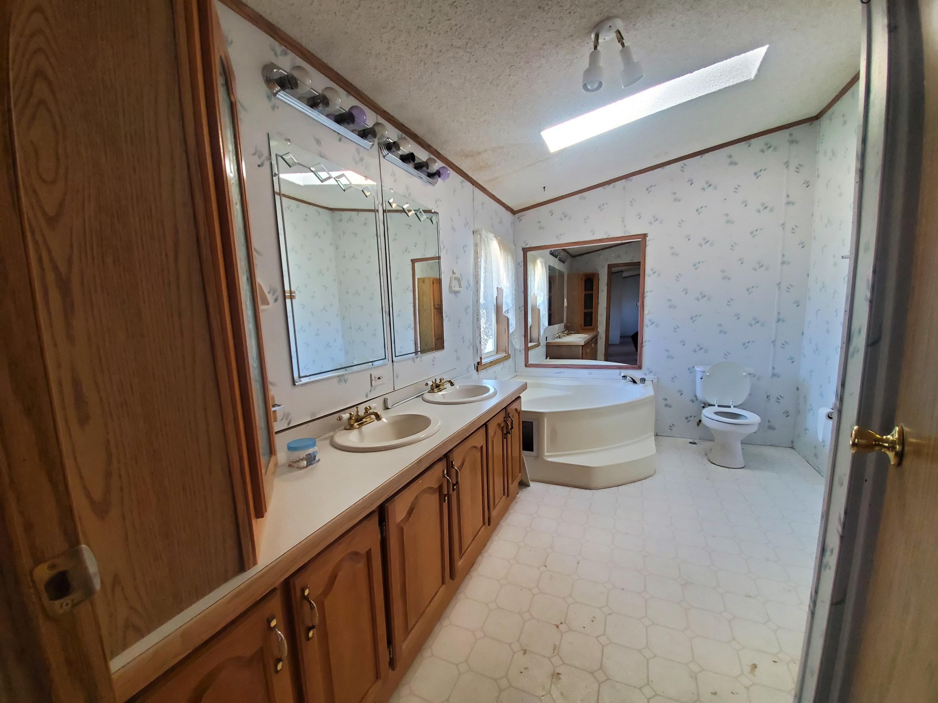 275 Roberts Road Craig, CO 81625 - Photo 14 of 16 a bathroom with a double vanity sink toilet and mirror
