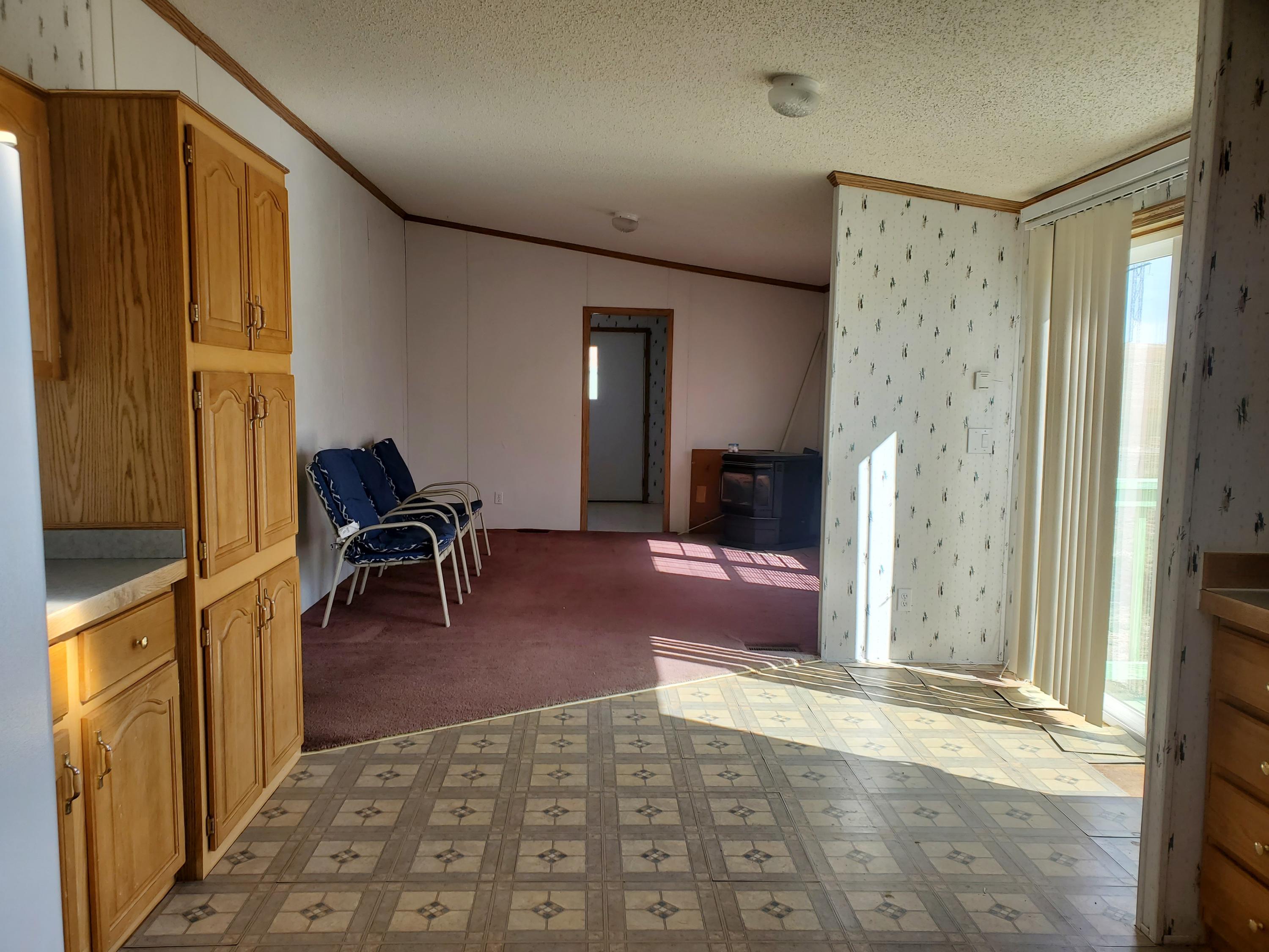 275 Roberts Road Craig, CO 81625 - Photo 10 of 16 a living room with furniture a dining table and a refrigerator
