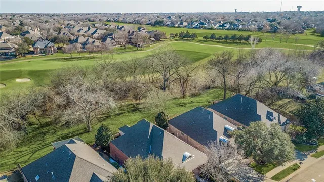 an aerial view of a house with a yard lake and outdoor seating
