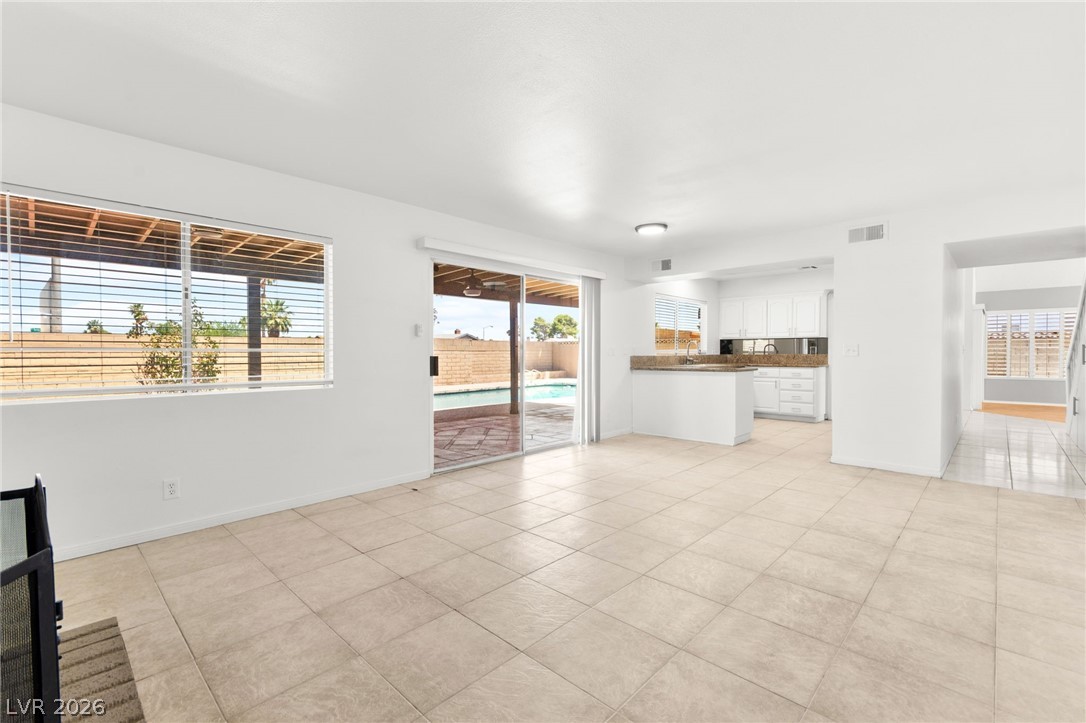 4430 Cranbrook Way Las Vegas, NV 89103 - Photo 17 of 50 A spacious living area seamlessly transitions to an outdoor oasis with a sparkling pool, perfect for leisure.