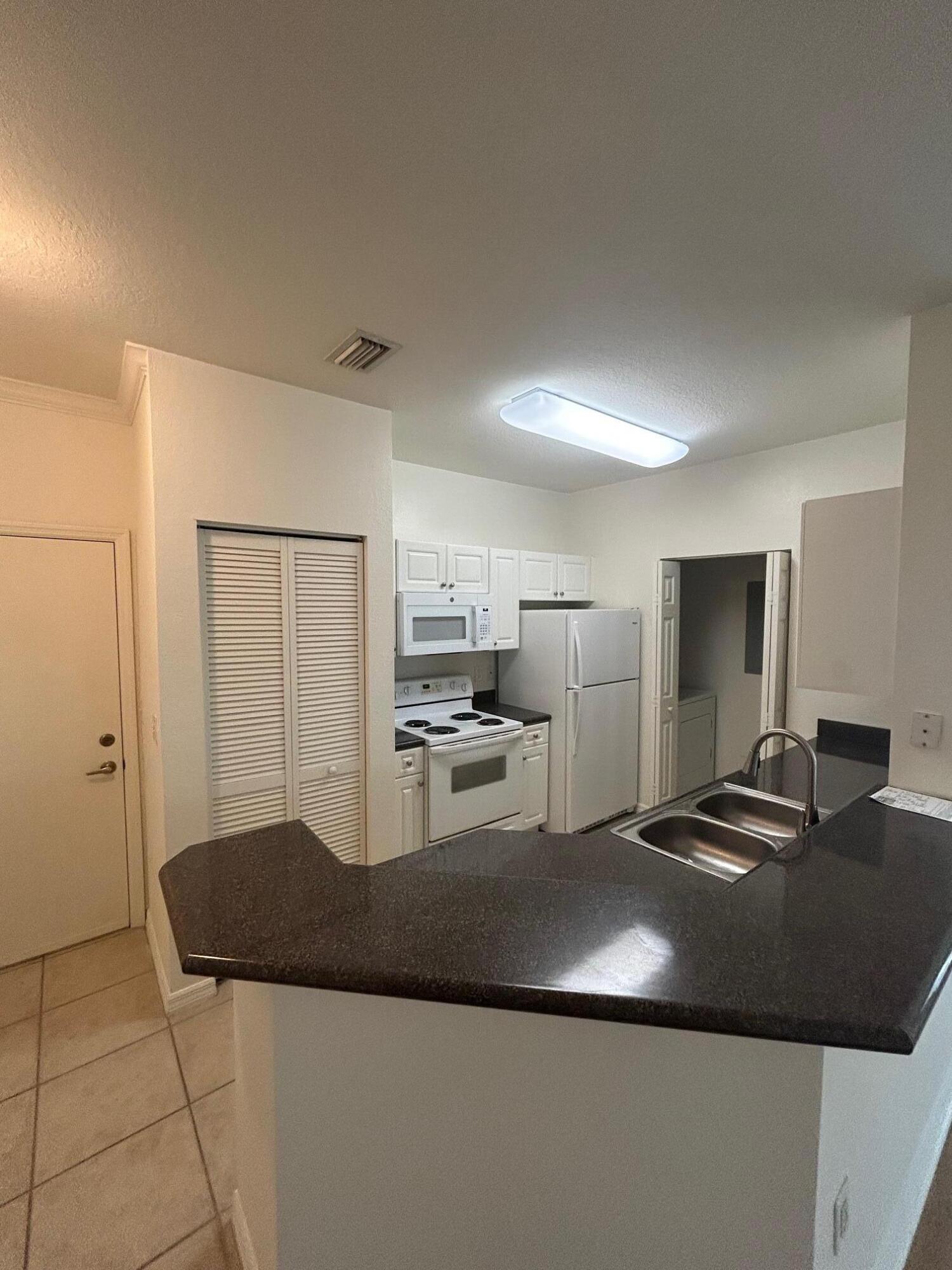 272 Southeast Kitching Circle Stuart, FL 34994 - Photo 14 of 23 a kitchen with kitchen island a counter top space a sink a stove and a refrigerator