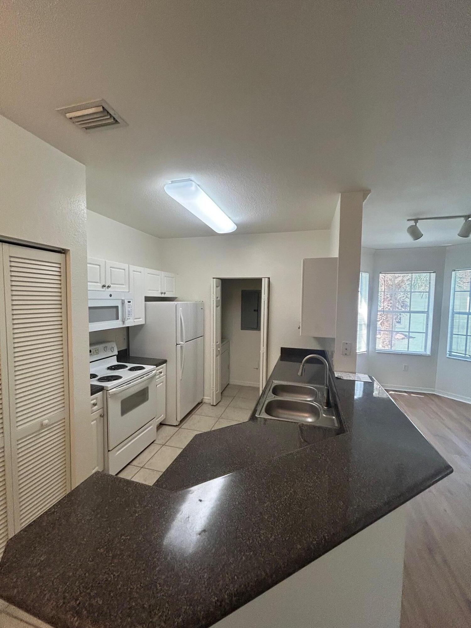 272 Southeast Kitching Circle Stuart, FL 34994 - Photo 15 of 23 a kitchen with kitchen island a sink stove and refrigerator