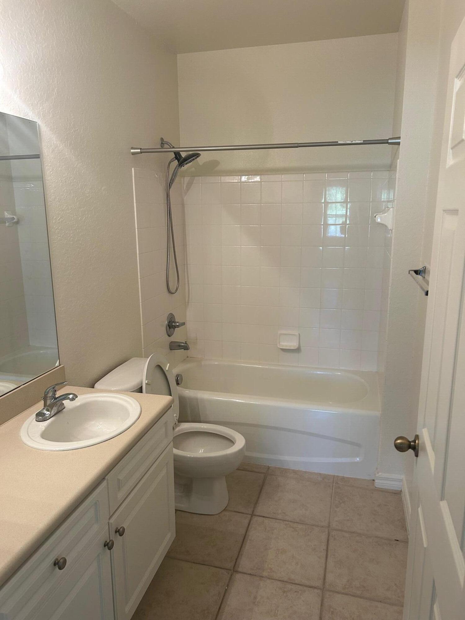 272 Southeast Kitching Circle Stuart, FL 34994 - Photo 3 of 23 a bathroom with a granite countertop bathtub shower sink vanity and a toilet