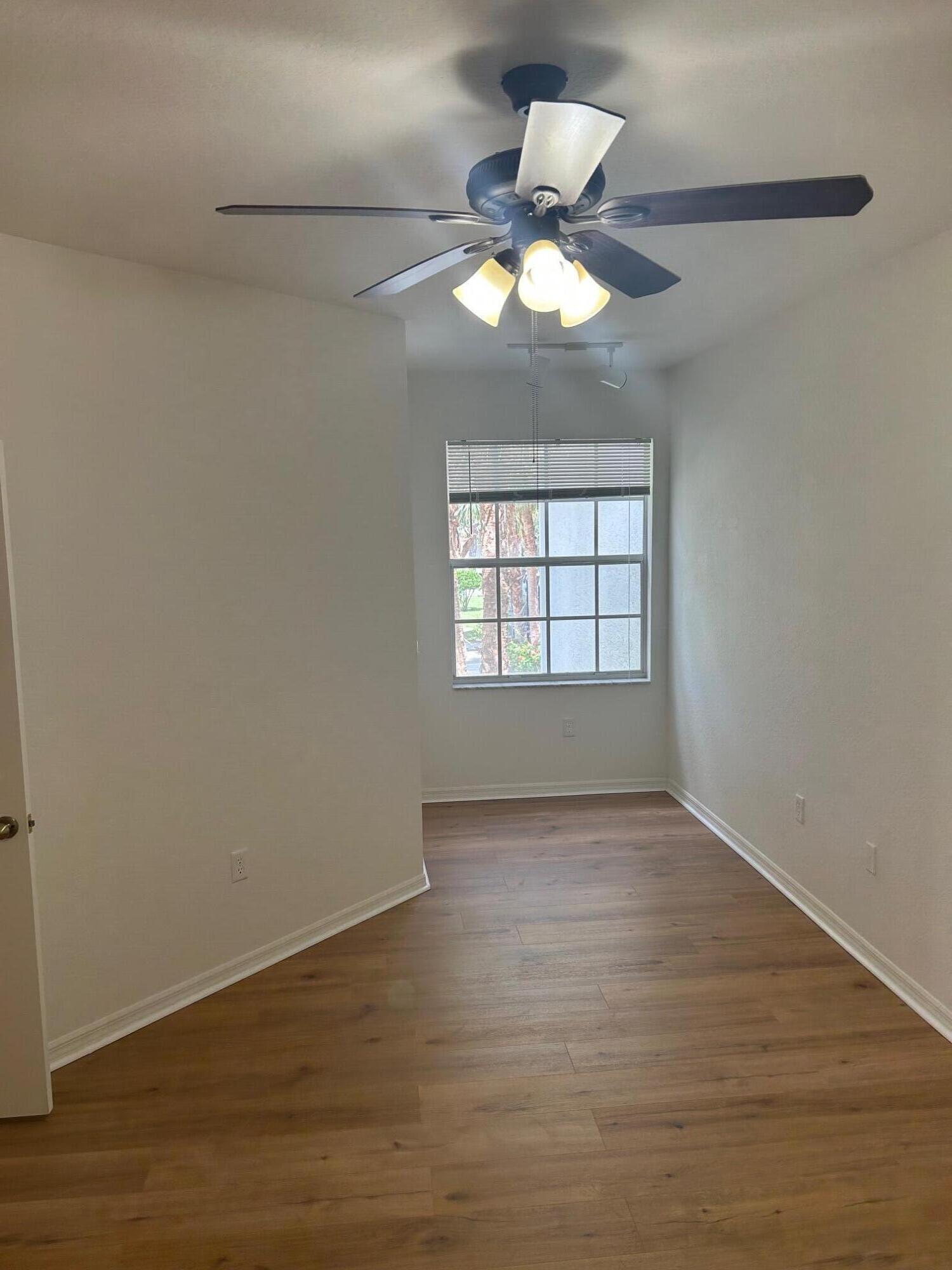 272 Southeast Kitching Circle Stuart, FL 34994 - Photo 6 of 23 a view of an empty room with wooden floor and a window