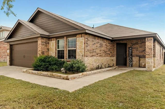 a front view of a house with yard and garage
