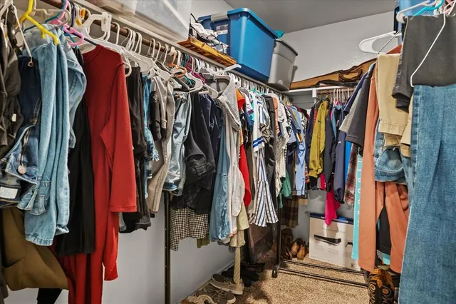 a view of walk in closet with clothes