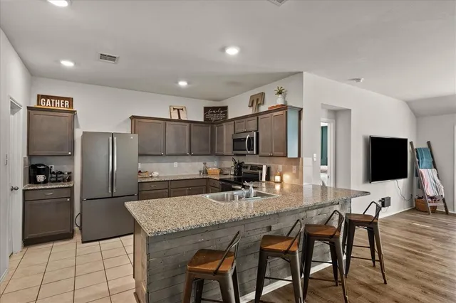 a kitchen with granite countertop a refrigerator and a stove top oven