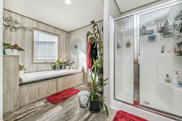 a bathroom with a tub shower and a mirror