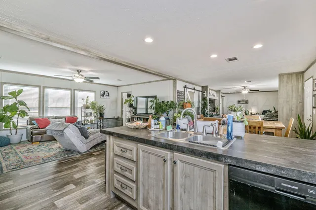 a kitchen with sink and view of living room