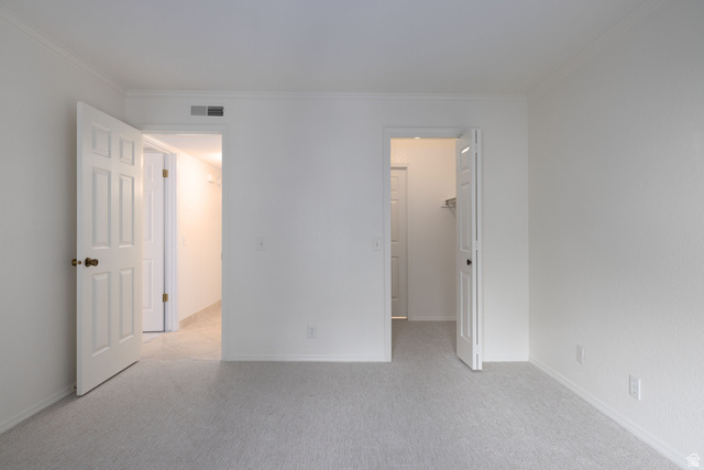 6936 South 775 East, Unit B Midvale, UT 84047 - Photo 17 of 33 Unfurnished bedroom with a spacious closet, light carpet, and crown molding