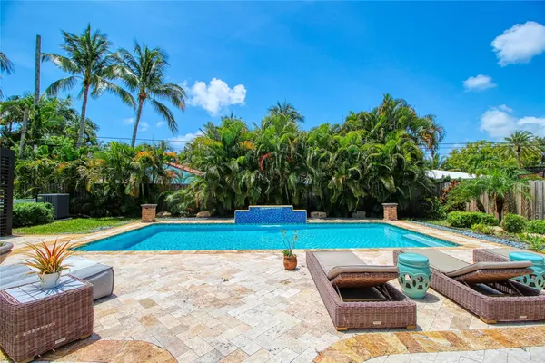 a view of backyard with swimming pool and furniture