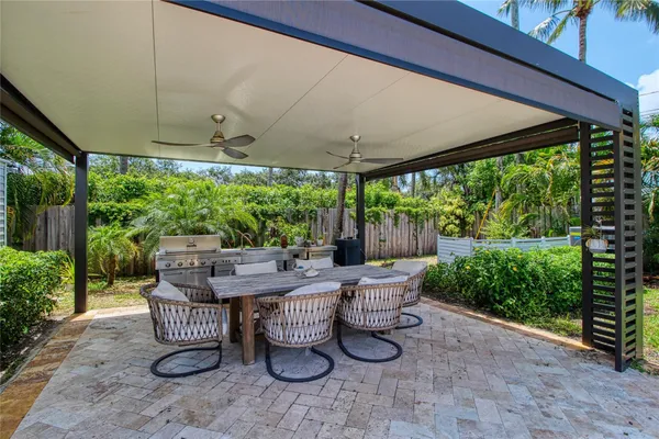 a view of a patio with table and chairs under an umbrella