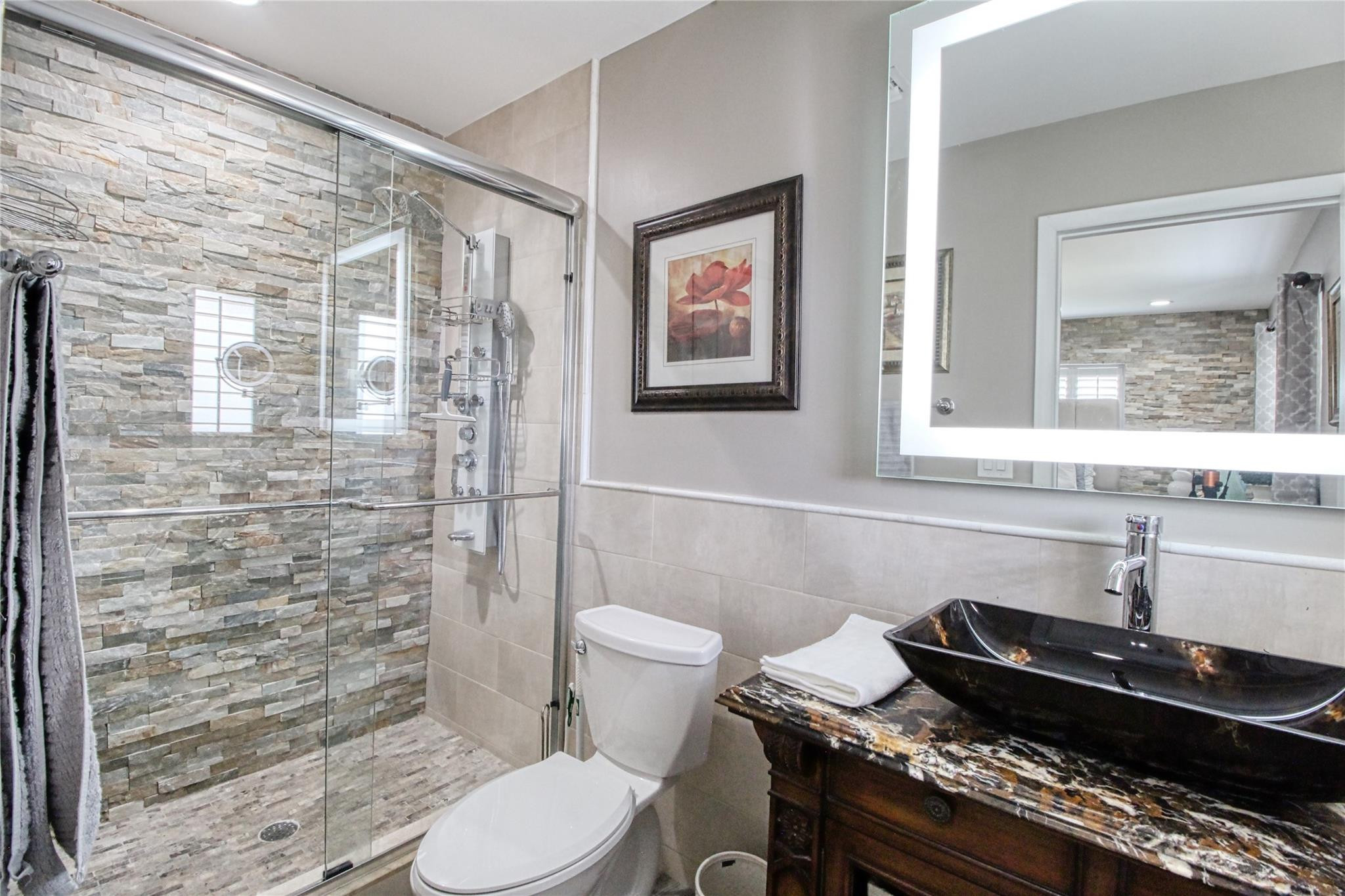 2080 Northeast 26th Street Lighthouse Point, FL 33064 - Photo 22 of 27 a bathroom with a granite countertop toilet a sink and a mirror