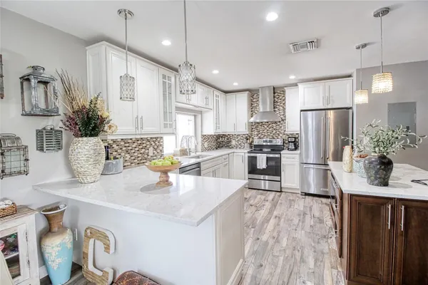 a dining hall with stainless steel appliances granite countertop a stove and a wooden floors