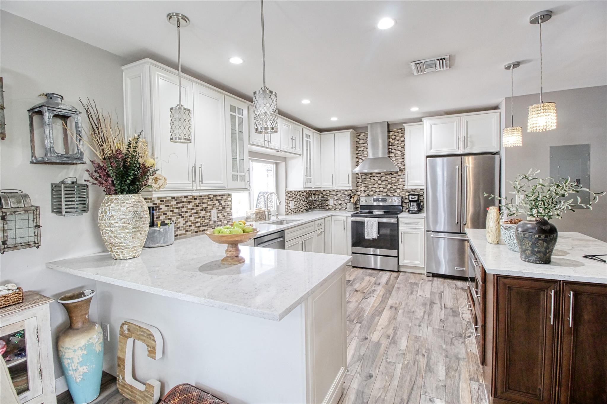 2080 Northeast 26th Street Lighthouse Point, FL 33064 - Photo 7 of 27 a kitchen with stainless steel appliances granite countertop a refrigerator a sink dishwasher a oven and a dining table with wooden floor
