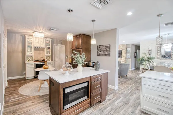 a kitchen with kitchen island granite countertop a sink a counter space appliances and cabinets