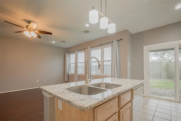 a bathroom with a granite countertop bathtub shower sink vanity and toilet