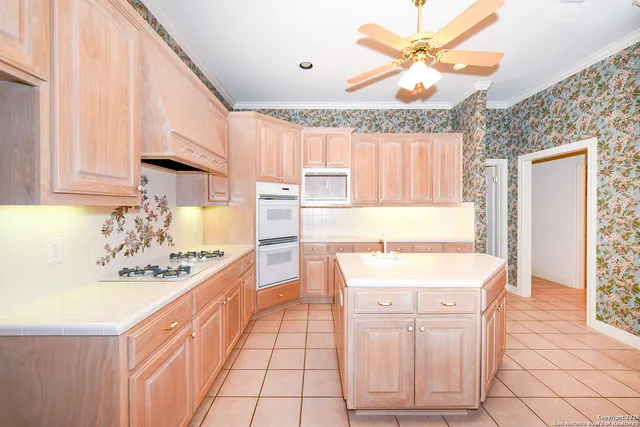 a kitchen with stainless steel appliances kitchen island granite countertop a sink a stove a dining table and chairs