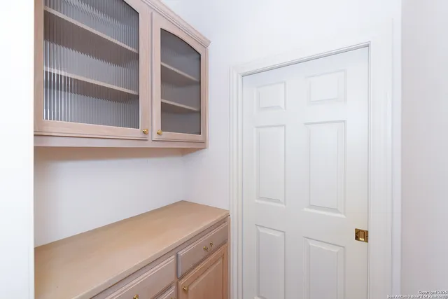 a utility room with a wooden floor and cabinets