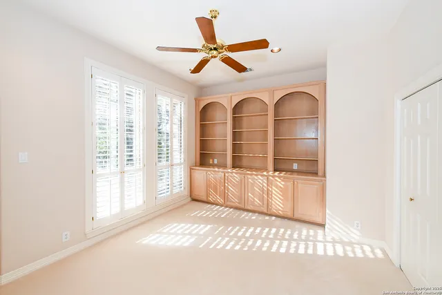a view of a livingroom with a ceiling fan and window
