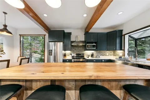 a kitchen with kitchen island a sink stove and refrigerator