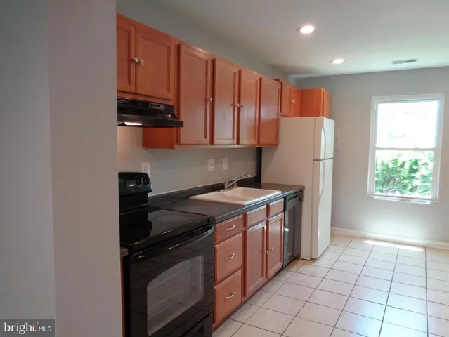 a kitchen with a stove a refrigerator and a sink