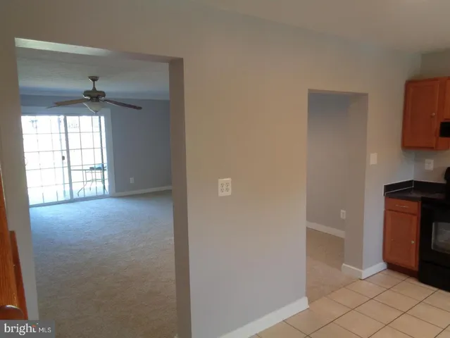 a view of an empty room with a fireplace and a window