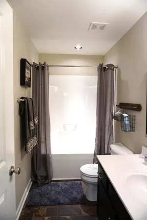 a bathroom with a sink a toilet a mirror and window
