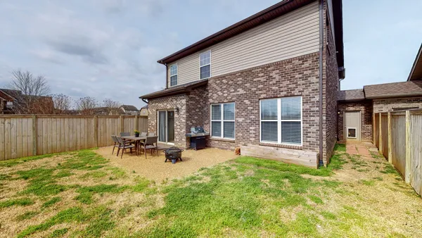 a view of a backyard with table and chairs and wooden fence