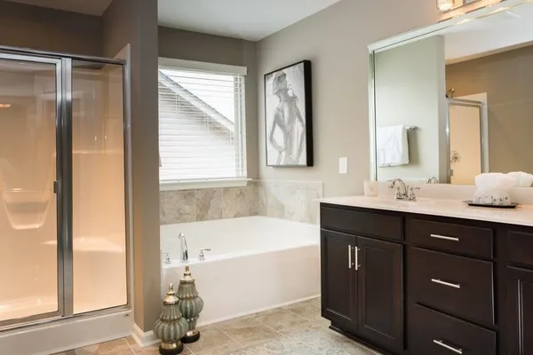 a bathroom with a tub sink and mirror