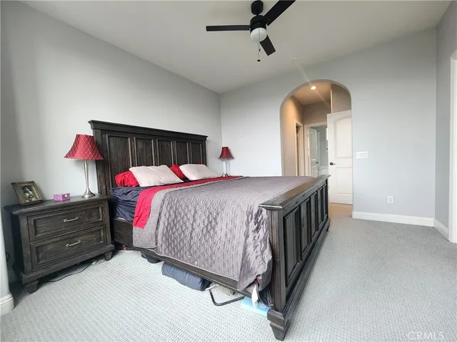 a bedroom with a bed a dresser and potted plants