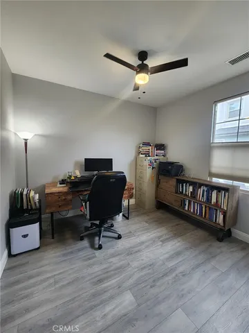 a view of a workspace with furniture and a window